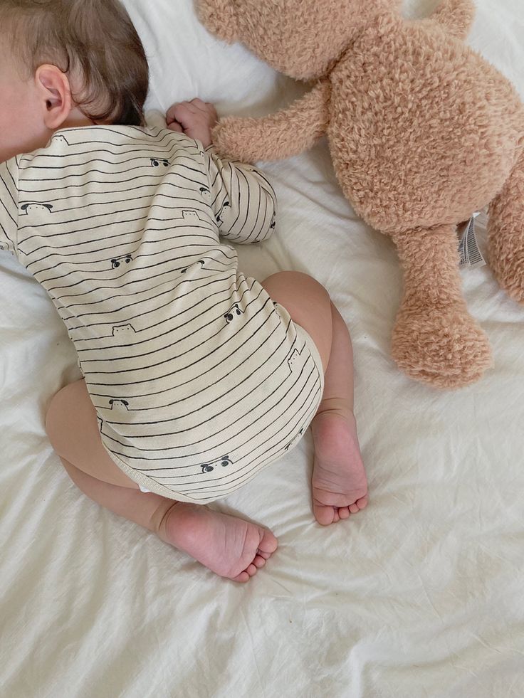 Bébé dormant sur le ventre avec sa peluche