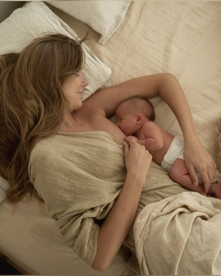 Bébé qui allaite maman sur le lit