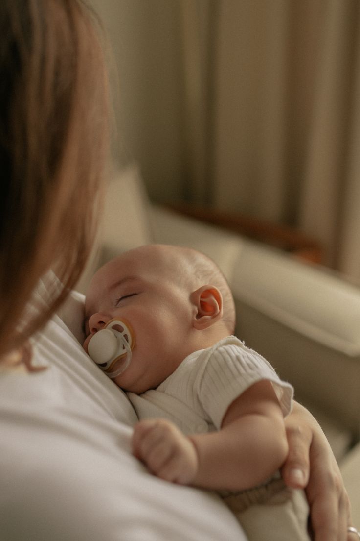 Bébé qui dort sur maman avec sa tétine