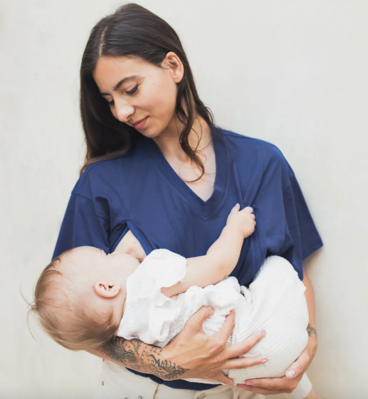 Photo d'une mère dans un t-shirt d'allaitement donnant le sein à son enfant.