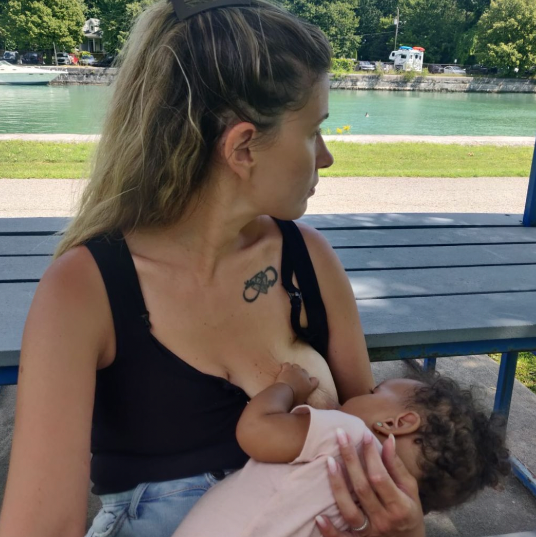 Femme allaitant son bébé dans un parc