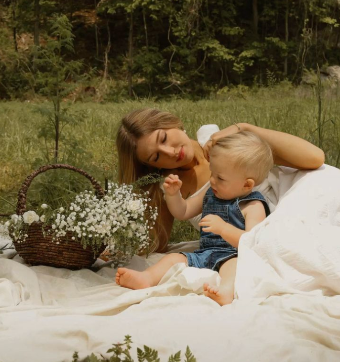 femme jouant dans l'herbe avec son bébé