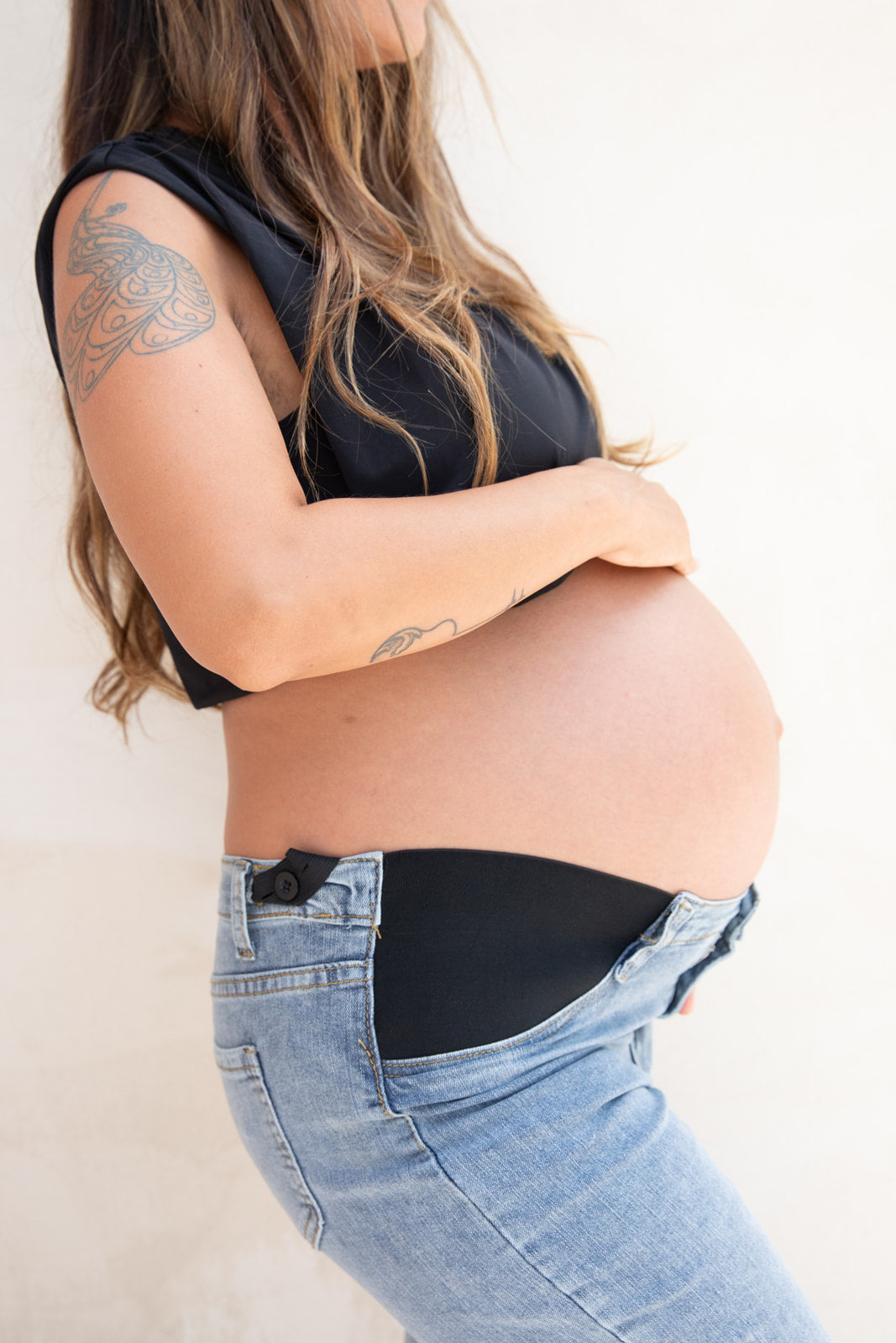 Jean de maternité réglable porté de profil, taille ajustable qui accompagne le ventre de femme enceinte