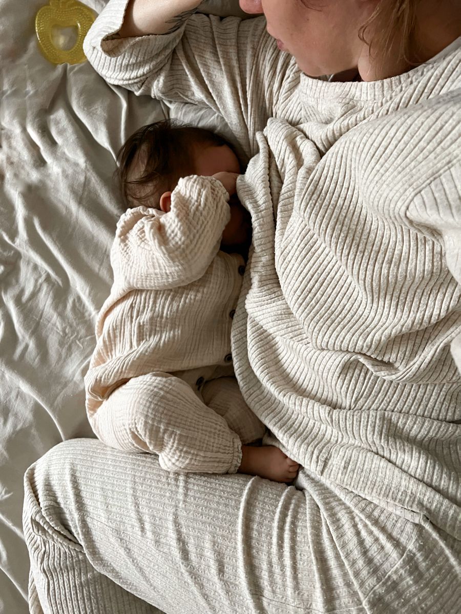 maman dans le lit allaitant son enfant 