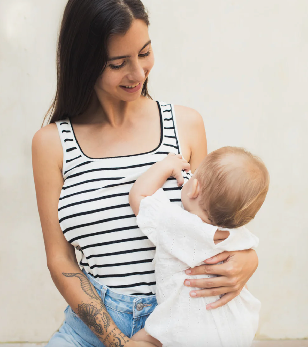 Jeune maman allaitant son bébé en débardeur marinière