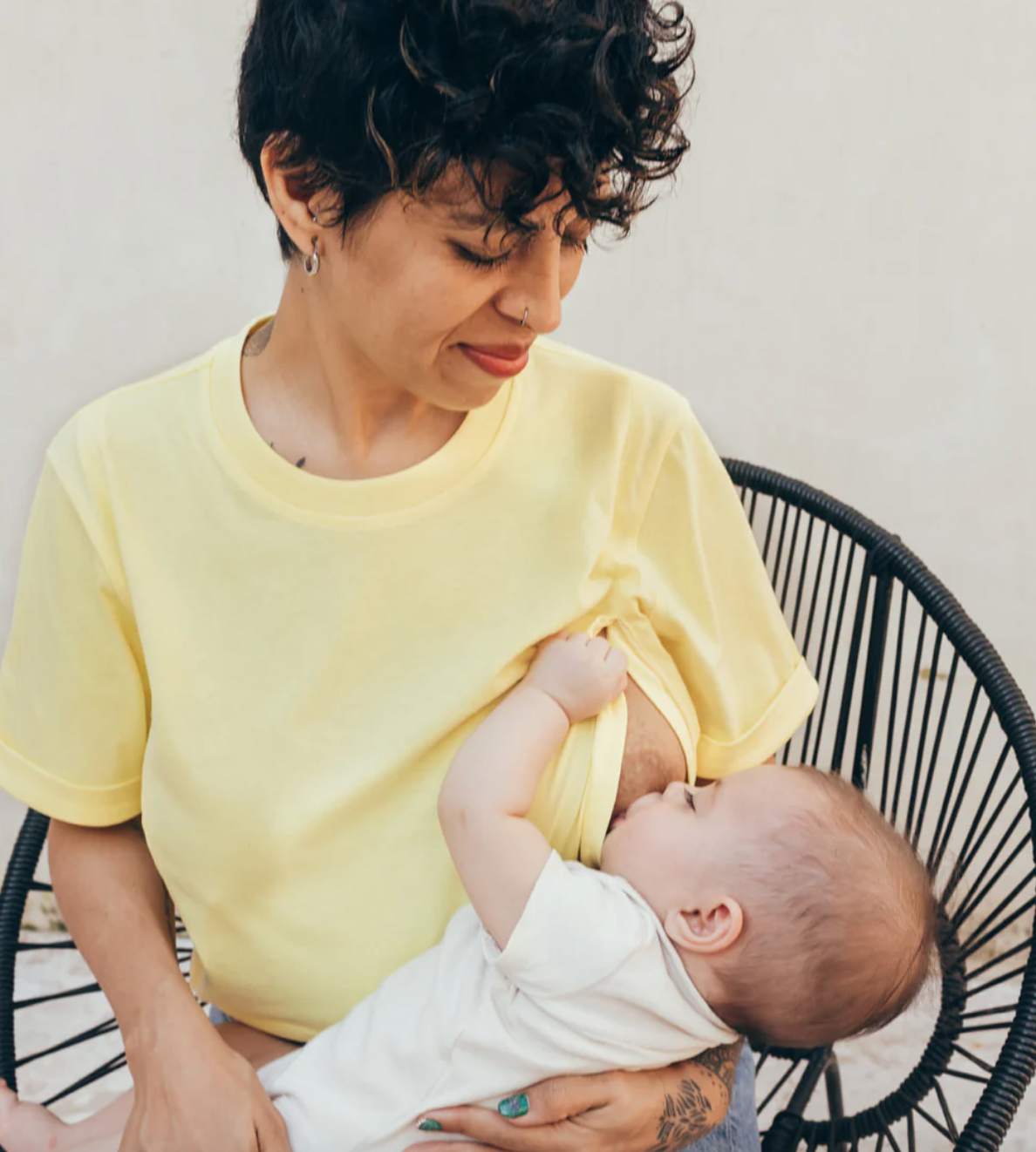 Woman breastfeeding her baby in a yellow T-shirt 