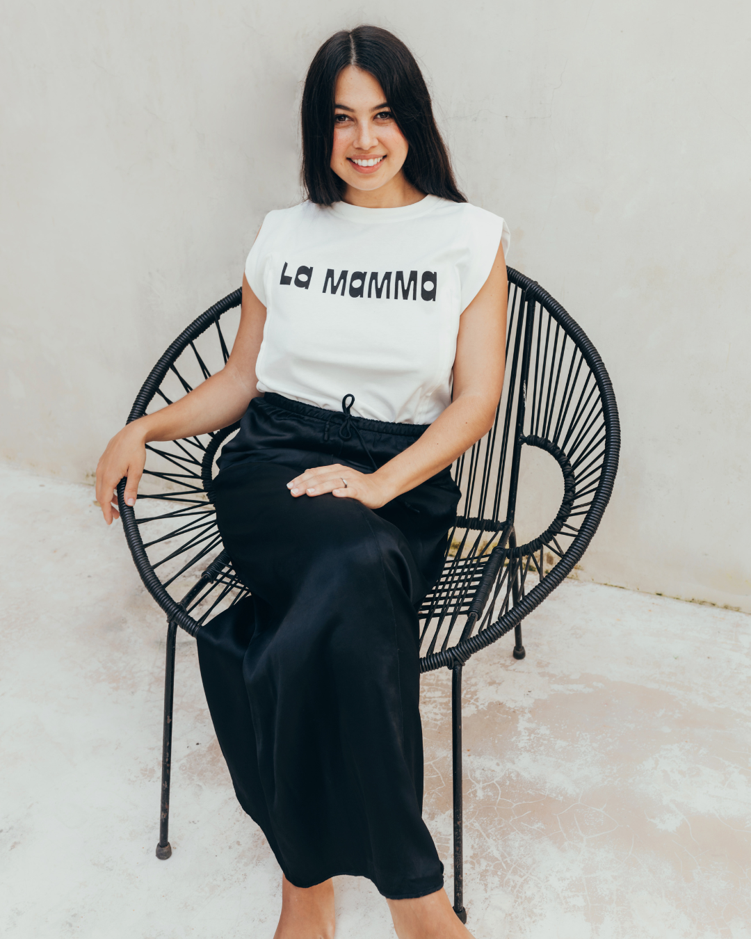Photographie d'une femme, assise sur une chaise, portant un t-shirt d'allaitement La Mamma de 23 Mai Paris