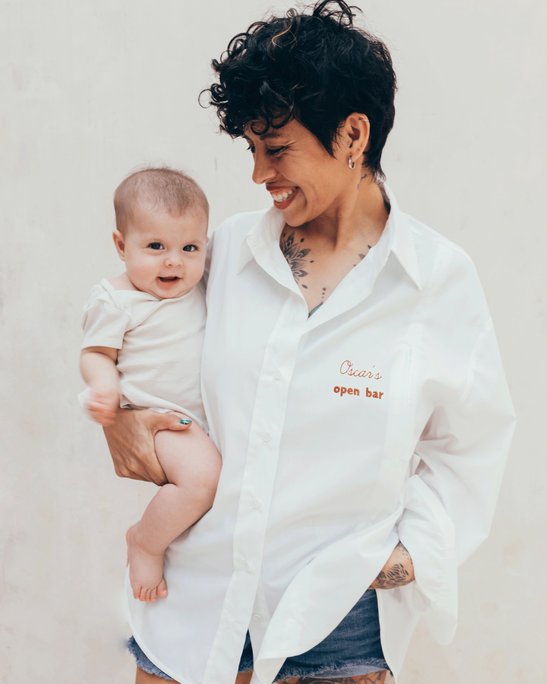 Photograph of a mother carrying her child, wearing a 23 Mai Paris nursing shirt.