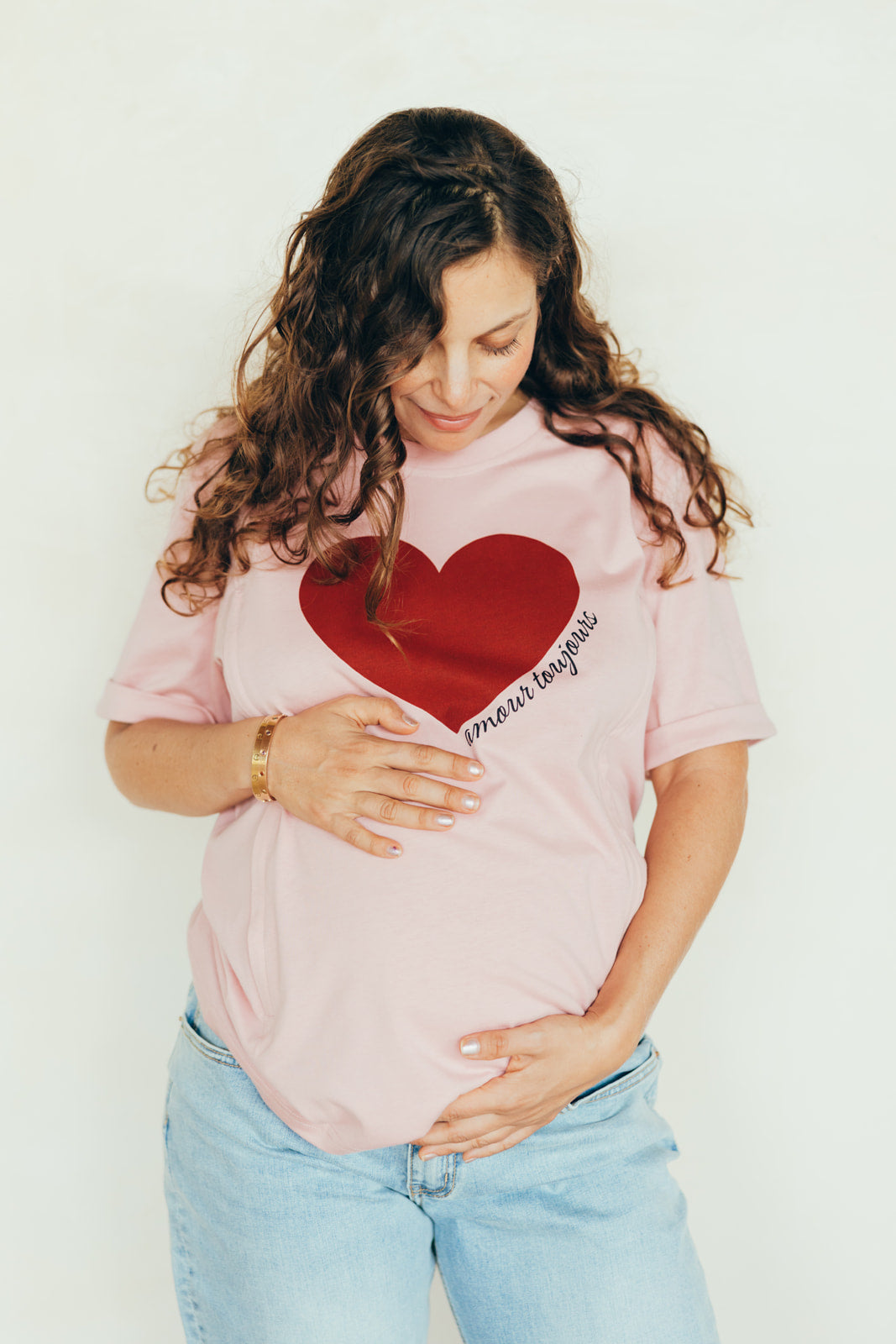 Femme enceinte avec un t-shirt rose avec un coeur 